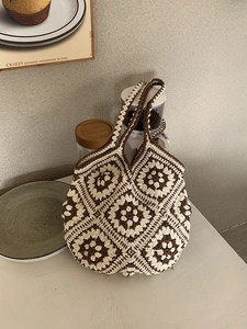 Detail of crochet tote bag with retro grandmother square floral patterns and twin straps