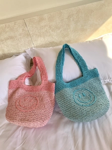 Detail of handmade crochet mini tote bags featuring cute yellow smiley faces
