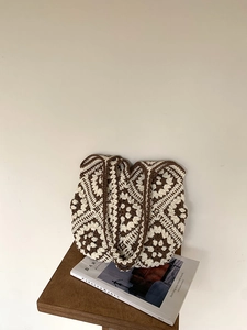 Detailed close-up of handmade crochet tote bag with brown and cream granny square patterns
