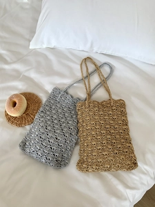 Close-up of handmade crochet bags with shell pattern in gold and silver metallic yarn