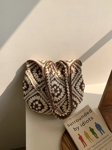 Detail of handmade crochet tote bag with boho granny square pattern in sunlight