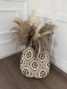 Close-up of handmade crochet tote bag featuring vintage brown and cream granny square patterns