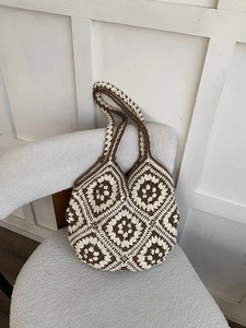 Close-up of handmade crochet tote bag with brown and cream granny square patterns