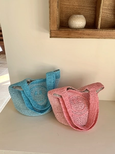 Close-up of pink and blue crochet mini bags with happy face and striped lining