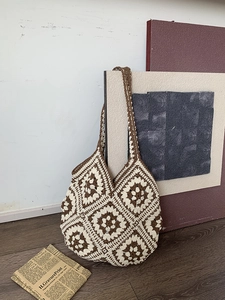 Close-up of handmade crochet tote bag featuring brown and cream granny square patterns