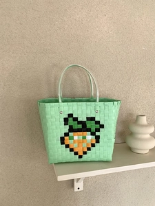 Handwoven light green beach tote bag with carrot pattern and clear round handles
