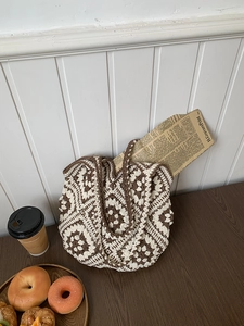 Close-up of handmade crochet tote bag featuring vintage floral patterns and knit texture