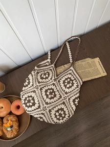Close-up of handmade crochet tote bag featuring brown and cream granny square floral patterns