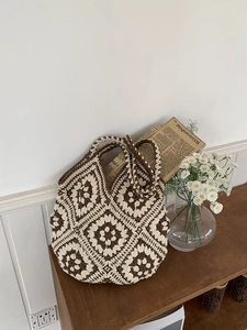 Detailed view of handmade crochet tote bag with retro floral patterns and hollow texture