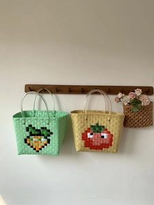 Detail of hand-woven plastic picnic baskets with carrot and tomato pixel patterns
