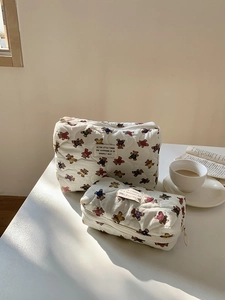 Détail de trousses de maquillage en coton matelassé avec imprimé ours et fermeture