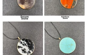 Detail view of four round natural stone pendants with gold plating and black cords