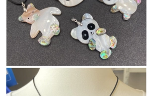 Détail du pendentif panda en nacre et ormeau montrant les reflets irisés de la coquille