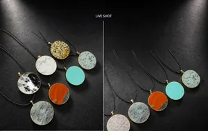 Detail of round natural stone pendants with gold metal edges and black cord necklaces