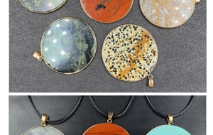 Close-up of round natural stone pendants with gold trim and black cord necklace