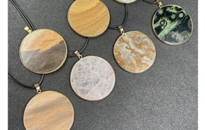 Macro shot of assorted round natural gemstone pendants with elegant gold metal frames