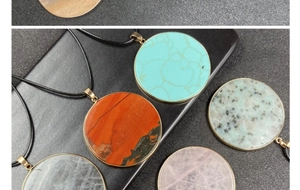 Close-up of circular natural stone pendants with gold plating and various gemstone textures