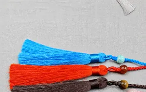 Close-up of colorful silk tassels with decorative beads in blue red and pink tones