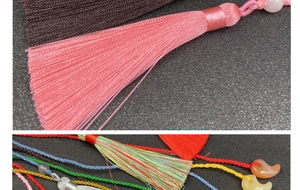 Makroaufnahme von handgefertigten Quasten mit bunten Magatama-Perlen und Seidenfransen