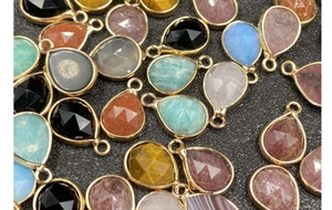 Close-up of faceted teardrop gemstone pendants with gold plating for jewelry DIY