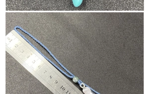 Blaue Kordel mit grüner Jadeperle und Lineal zur Messung der 10cm Länge im Detail