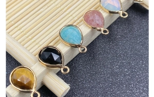 Detailed view of teardrop faceted gemstones with gold-plated edges for DIY jewelry making
