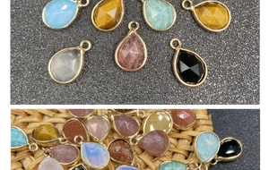 Macro shot of faceted teardrop charms with gold-plated edges in various vibrant colors
