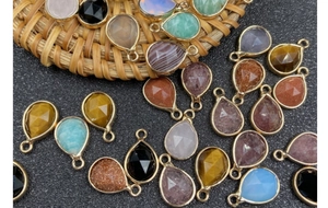 Macro view of faceted teardrop gemstone pendants with gold-plated edges for DIY jewelry