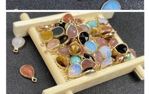 Macro view of teardrop faceted gemstones with gold plated frames for jewelry making