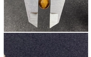 Detailed measurement of a faceted tiger eye stone pendant with gold edging using a caliper