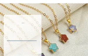 Macro detail of star-shaped crystal pendants in various colors on golden chain necklaces