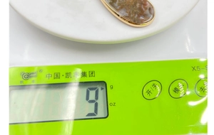 Λήψη macro ενός μενταγιόν από αχάτη βρύων 9g με χρυσό περίγραμμα σε ψηφιακή ζυγαριά