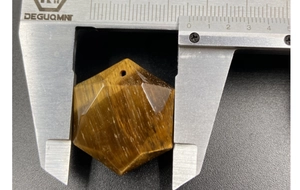 Dettaglio del pendente in occhio di tigre da 34mm misurato con un calibro di precisione
