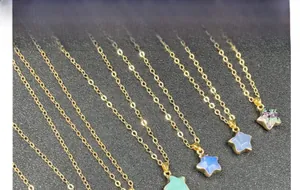 Detail view of colorful star crystal pendants on gold-plated chains for women