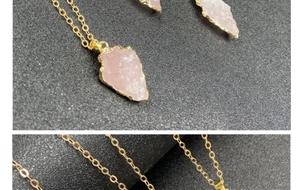 Vue macro du pendentif en quartz rose en forme de flèche avec bords dorés et chaîne fine