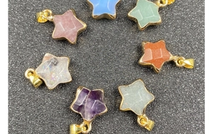 Macro shot of assorted star-shaped gemstone pendants with elegant gold-plated edging