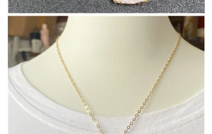 Collier quartz rose en forme de flèche avec bord doré porté par un mannequin en t-shirt