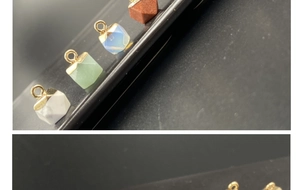 Macro detail of geometric gemstone pendants with gold plated edges on a matte surface