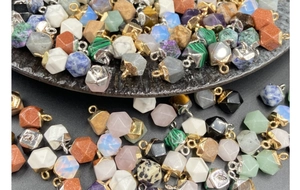 Macro shot of faceted hexagonal crystal pendants with gold and silver metal bails