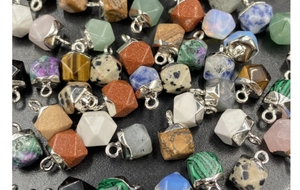 Macro shot of assorted faceted natural stone pendants with silver-plated bails and rings