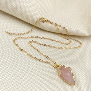 Collier pointe de flèche en quartz rose doré à l'or sur texture de lin blanc