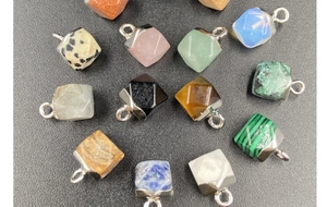 Close-up of assorted hexagonal gemstone pendants with polished silver metal caps