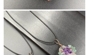 Détail du pendentif arbre de vie avec cristaux et pierres violettes sur cordon noir