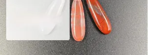 Macro shot of polished water drop agate pendants with natural stone textures and holes
