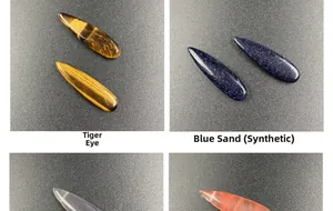 Macro detail of polished tiger eye and blue goldstone teardrop pendants showing smooth texture