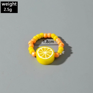 Macro shot of handmade beaded ring with yellow lemon charm and size specifications