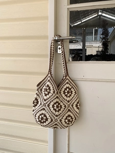 Close-up of handmade crochet tote bag featuring vintage granny square patterns and cotton texture