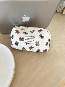 Détail de la texture matelassée et de l'imprimé ours sur la trousse de toilette blanche