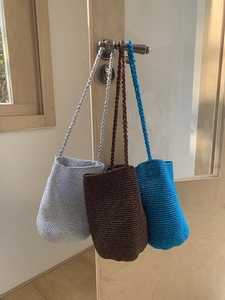 Texture détaillée de sacs seaux tissés à la main en argent, marron et bleu royal