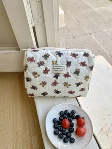 Trousse à maquillage matelassée blanche avec motifs d'ours colorés et étiquette tissée